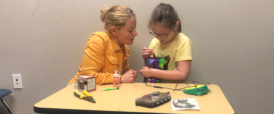 Heather Grace works with a young girl who is building a toy.