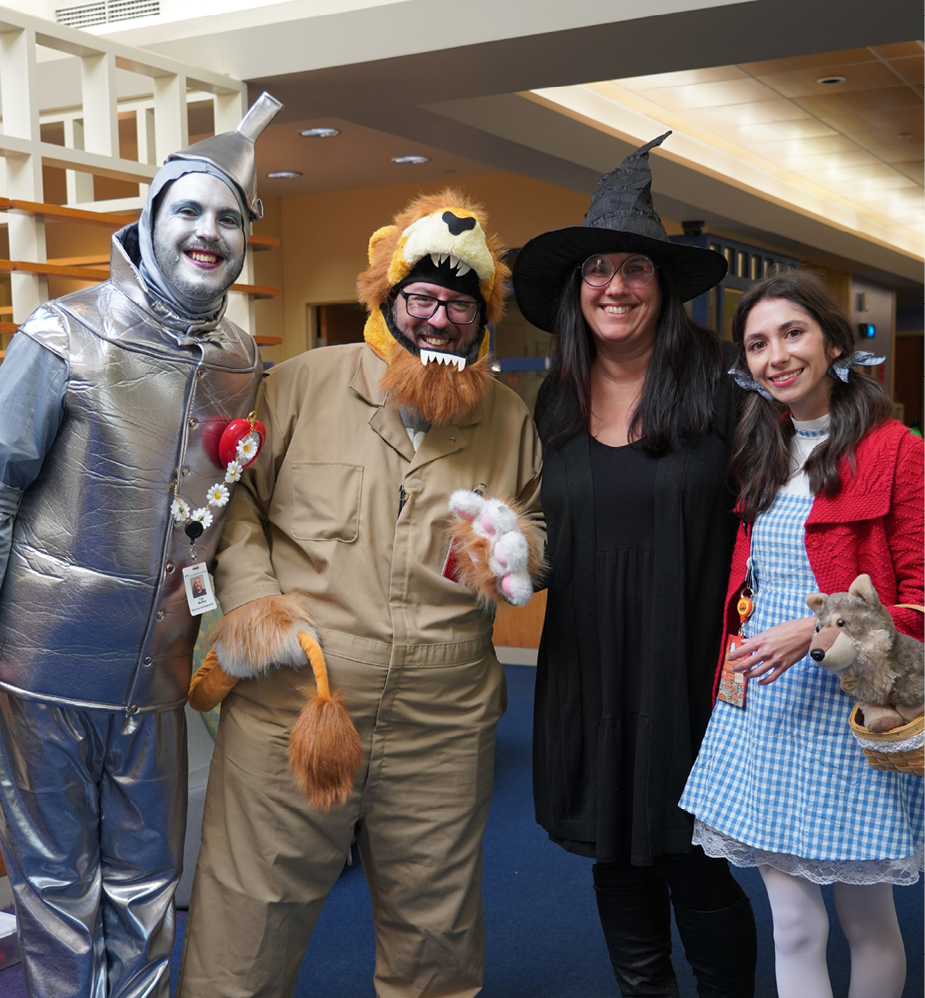 Four coworkers dressed as characters from the Wizard of Oz for a Halloween celebration at a children's health center