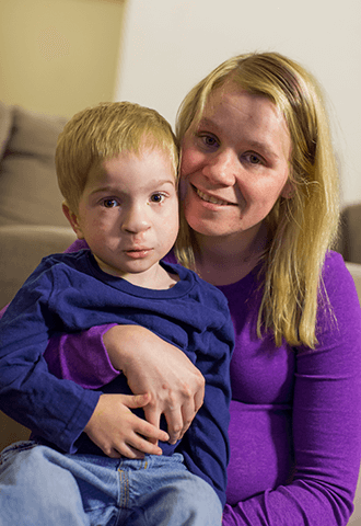 Mom holding son, both smiling